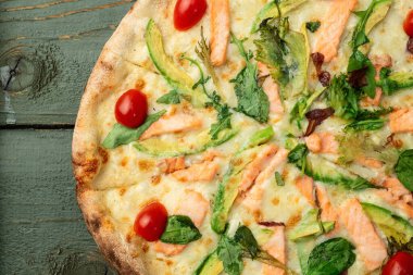 Avokado somon domatesli İtalyan pizzası ve mozzarella fotoğrafçılığı. Kırsal arkaplanda üst görünüm