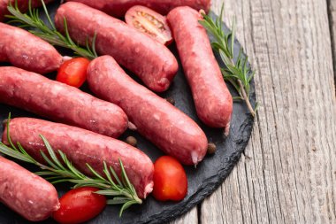 Biberiyeli çiğ et sosisi ve domates fotoğrafçılığı. Kırsal arkaplanda üst görünüm