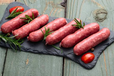 Biberiyeli çiğ et sosisi ve domates fotoğrafçılığı. Kırsal arkaplanda üst görünüm