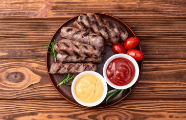 Biberiye soslu ızgara biftek ve domates fotoğrafçılığı. Kırsal arkaplanda üst görünüm