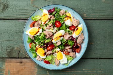 Yumurta ve domates fotoğraflı konserve ton balığı salatası. Kırsal arkaplanda üst görünüm