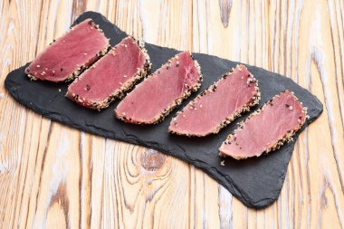 Susamlı dilimlenmiş ton balığı bifteği. Kırsal arkaplanda üst görünüm