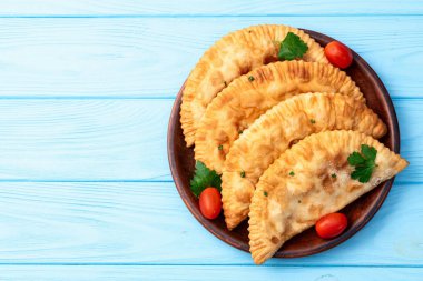 Atıştırmalık çizelgeler. Et fotoğrafçılığı yapan börekler. Kırsal arkaplanda üst görünüm