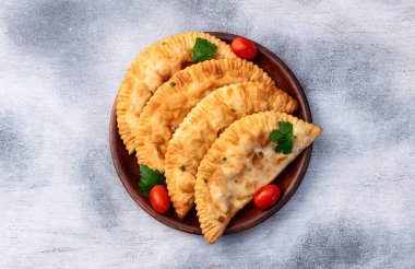 Atıştırmalık çizelgeler. Et fotoğrafçılığı yapan börekler. Kırsal arkaplanda üst görünüm