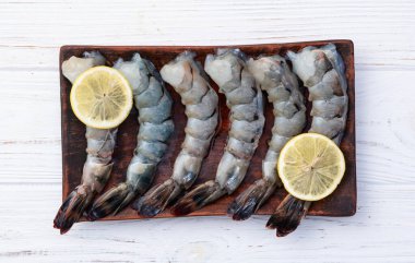 Çiğ büyük kaplan (kral) karidesleri temizler, soyarlar ve biçerdöverler. Kırsal arkaplanda üst görünüm