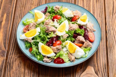 Yumurta ve domates fotoğraflı konserve ton balığı salatası. Kırsal arkaplanda üst görünüm