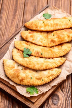 Atıştırmalık çizelgeler. Et fotoğrafçılığı yapan börekler. Kırsal arkaplanda üst görünüm