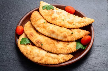 Atıştırmalık çizelgeler. Et fotoğrafçılığı yapan börekler. Kırsal arkaplanda üst görünüm