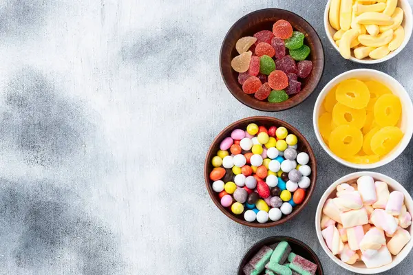 Renkli şekerlerin karışımı. Kırsal arkaplanda üst görünüm çeşitliliği