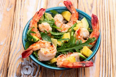 Kaplan karidesli salata, avokado ve mango. Kırsal arkaplanda üst görünüm