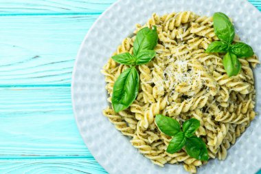 Fesleğen soslu makarna. İtalyan yemek fotoğrafçılığı. Kırsal arkaplanda üst görünüm