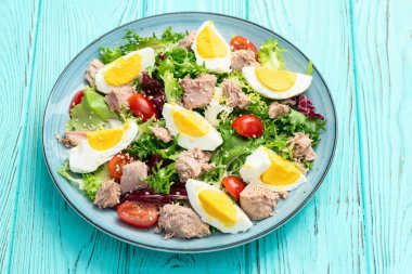 Yumurta ve domates fotoğraflı konserve ton balığı salatası. Kırsal arkaplanda üst görünüm