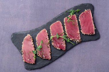 Susamlı dilimlenmiş ton balığı bifteği. Kırsal arkaplanda üst görünüm