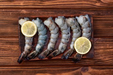 Çiğ büyük kaplan (kral) karidesleri temizler, soyarlar ve biçerdöverler. Kırsal arkaplanda üst görünüm