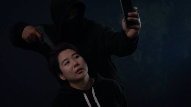 Suçlu ya da maskeli haydut genç bir kadını rehin alarak silah tutuyordu. Fidyeci ya da soyguncu silah zoruyla kadın rehin alınmış ve fidye istenmiş.