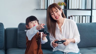 Mutlu anne ve çocuğu birlikte oturma odasında oyun oynuyorlar mutlu sevgi dolu bir aile, Asyalı anne ve kız evde oyun kontrolüyle birlikte.