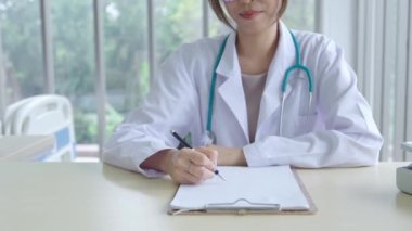 Smiling asian female doctor in the office , Portrait of beautiful mature woman doctor is committed to treating patients. healtcare and assistance concept