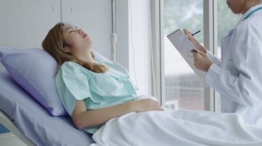 A young female patient listens to the results of the doctor's examination in the hospital bed