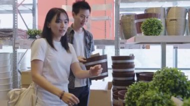 Portrait of young smart asian female shopping new lifestyle , New normal after covid epidemic young couple asia choose home interior of stock product inventory on shelf in supermarket