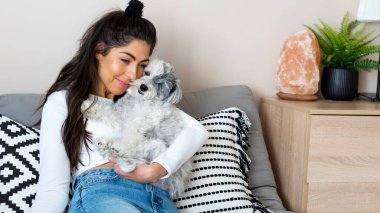 Güzel genç bir kadın, Beyaz kıdemli Havan Köpeğine sarılıyor. 