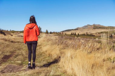 Sofya kentinin yukarısındaki sonbahar dağında yüksek bir kayanın üzerinde duran bir kadın. Vitoşa Dağı, Bulgaristan