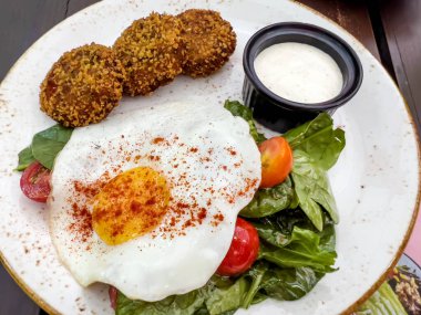 Fried eggs with spinach salad