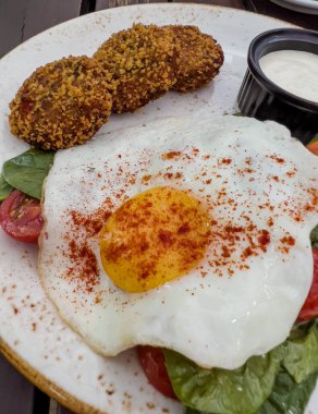 Fried eggs with spinach salad