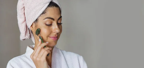 stock image Beautiful woman using green jade roller for face massage . Daily Jade Roller Facial Massage Routine