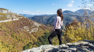 Traveler Woman standing on a rocks in the autumn mountain with scenery view . Balkan mountains, ,Bulgaria