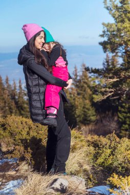 Happy Woman and Kid in the Winter Mountain .Family Time in the Nature