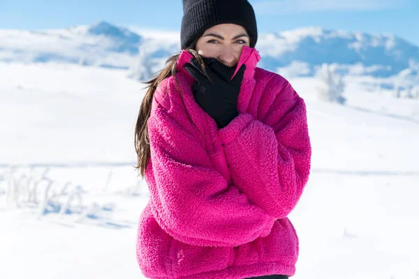 Young woman in the cold winter mountain trying to warm herself. Winter concept