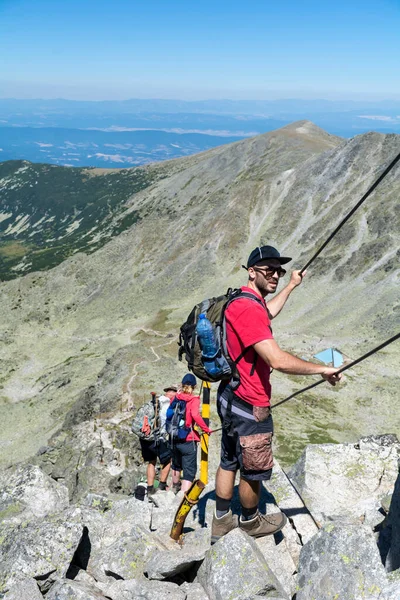 Young man hiking in the summer mountain in Bulgaria  .Rila Mountain, Musala peak
