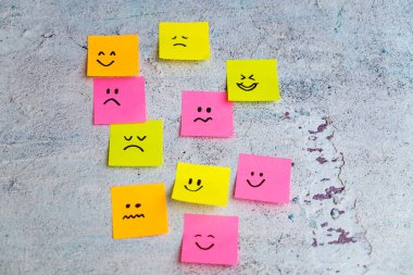 Mavi arka planda farklı duyguları olan bir sürü yapışkan not. Empati Konsepti