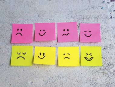 Mavi arka planda farklı duyguları olan bir sürü yapışkan not. Empati Konsepti