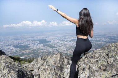 Yaz dağının zirvesinde oturan muhteşem manzaralı bir kadın.