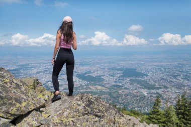Yaz dağının zirvesinde oturan muhteşem manzaralı bir kadın.