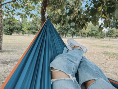Yaz parkında hamakta kadın bacakları.