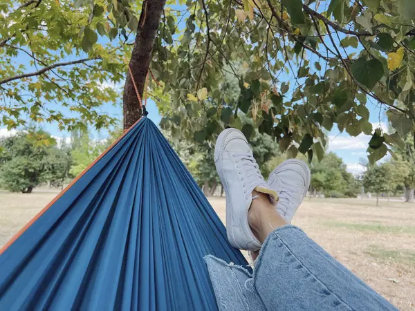 Women\'s legs in a hammock in a summer park