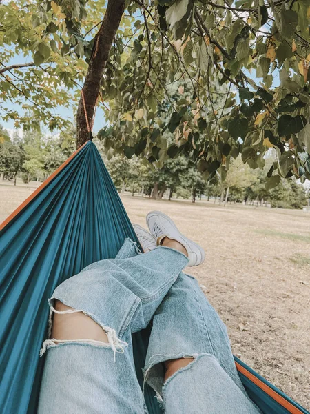 Women\'s legs in a hammock in a summer park