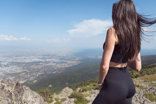 Yaz dağının zirvesinde oturan muhteşem manzaralı bir kadın.