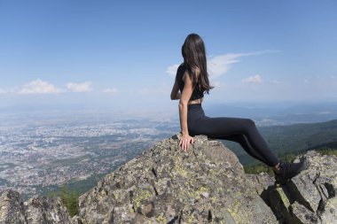 Sofya şehrinin yukarısındaki yaz dağında kayalarda oturan bir kadın.