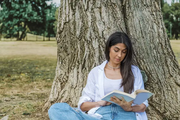 Woman reading a book in the summer park