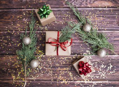 Ahşap arka planda kırmızı kurdeleli hediye kutuları. Noel hediyeleri.