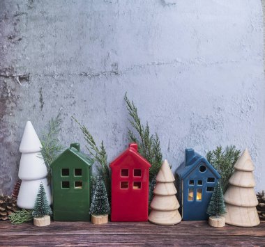 Noel odasının iç dekorasyonu İskandinav tarzında ahşap küçük evler ve çam ağaçlarıyla süslenmiş.