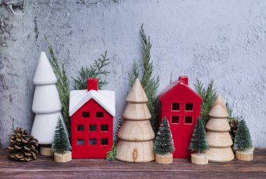 Noel odasının iç dekorasyonu İskandinav tarzında ahşap küçük evler ve çam ağaçlarıyla süslenmiş.