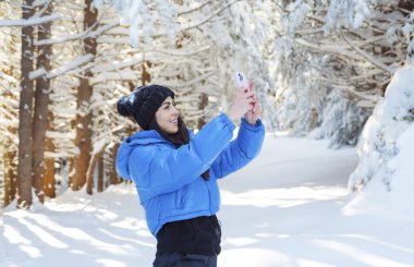 Genç kadın güzel Kış Dağı 'nda fotoğraf çekiyor.
