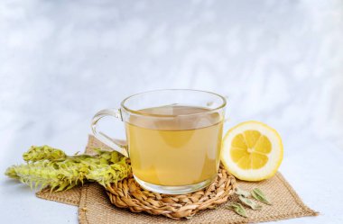 Ahşap zemin üzerinde Mursala çayı ve limon olan cam bardak.