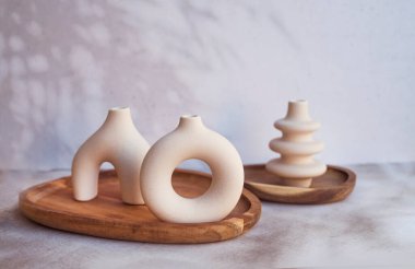 Ahşap tepside modern bej seramik küçük vazolar. İskandinav iç mimarisi