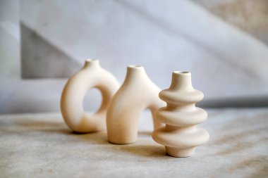 Ahşap tepside modern bej seramik küçük vazolar. İskandinav iç mimarisi