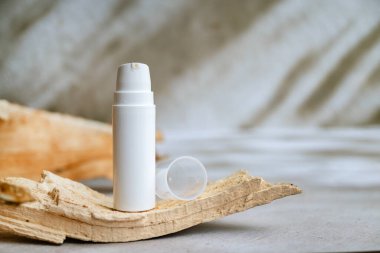 Arka planda beyaz bir şişede yüz kremi. 